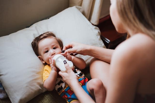 Baby Playing With A Bottle Instead Of Drinking