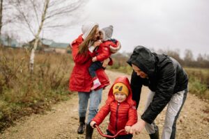 A family enjoying quality time outdoors, walking and playing together in the countryside.